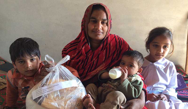 Mother with three young children receiving food gift from Messiah Missions.